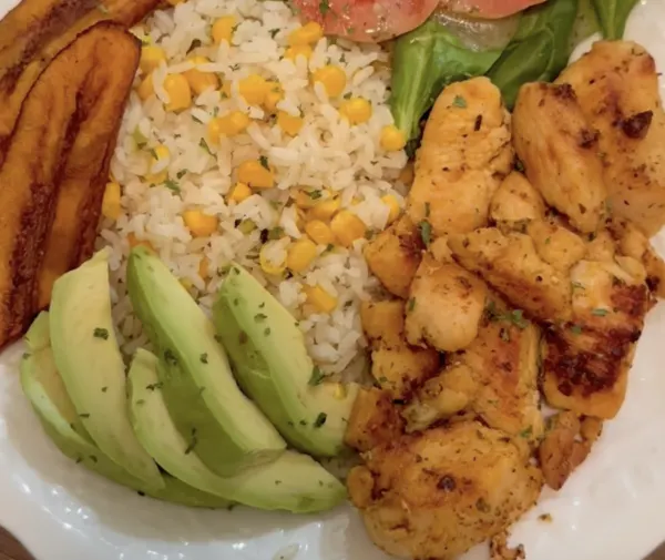 Plato criollo del mediodía: pollo, arroz con maíz y aguacate